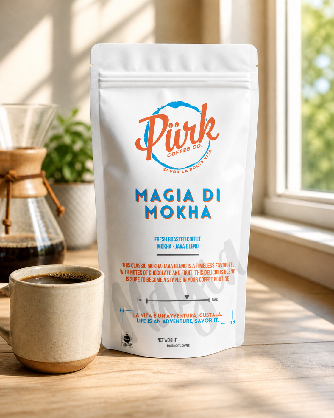 A bag of PÜRK Coffee Co.'s Magia Di Mokha coffee sitting on a table by a window beside a fresh brewed cup of coffee.